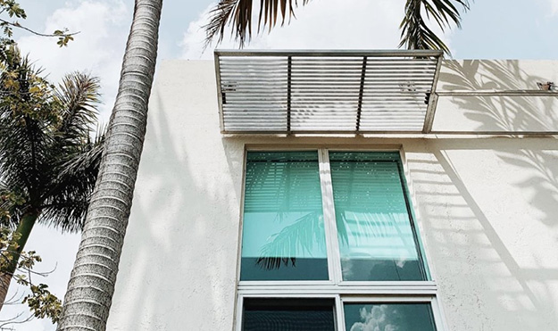 White building exterior with palm trees nearby