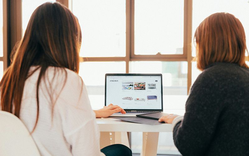 Two women looking at a laptop