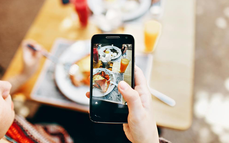 Person taking photo of food on their phone