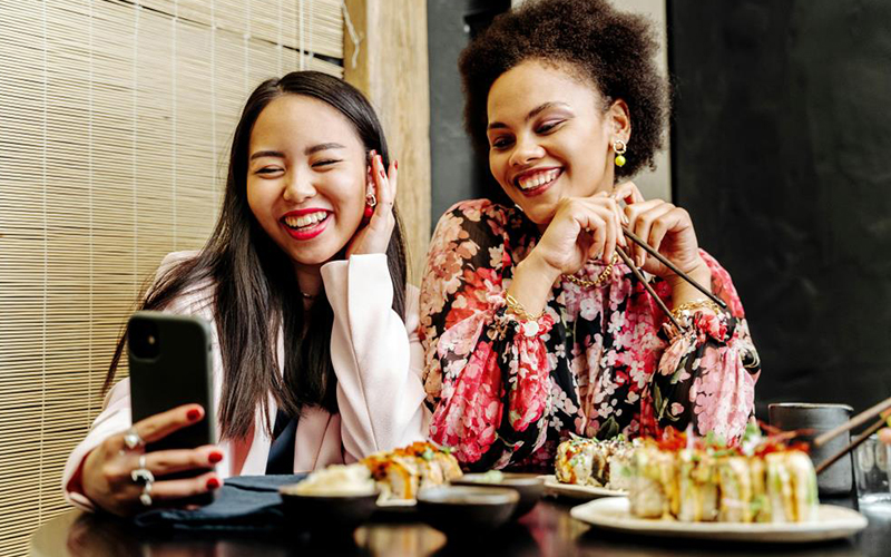 2 Women taking a selfie at a restaurant table