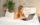 A woman lying on a bed with a laptop